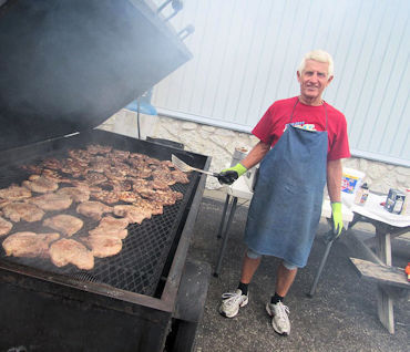 Jim Harrison standing over a BBQ