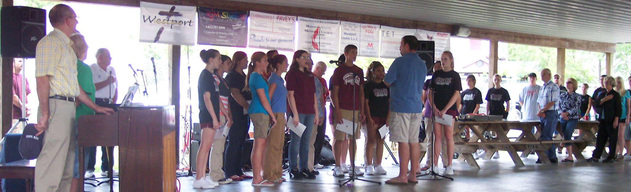 Photo of a group of teens singing under the shelter house
